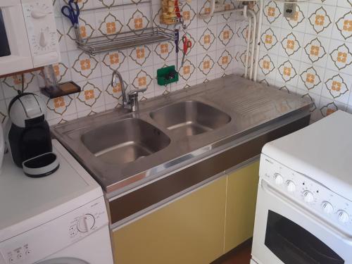 Il comprend une cuisine équipée d'un évier en acier inoxydable et d'une cuisinière. dans l'établissement Studio Cabine 4 Pers. Face Mer avec Parking - Port Leucate - FR-1-798-32, à Leucate