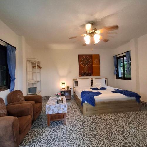 a bedroom with a bed and a couch and a ceiling at D&K Smiley Phuket Resort in Rawai Beach
