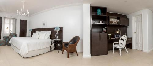 a bedroom with a bed and a desk and chairs at La Mision Hotel Boutique in Asuncion