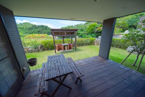 a wooden deck with a bench and a gazebo at Churaumi Village Motobu-Fuji-Karst in Motobu