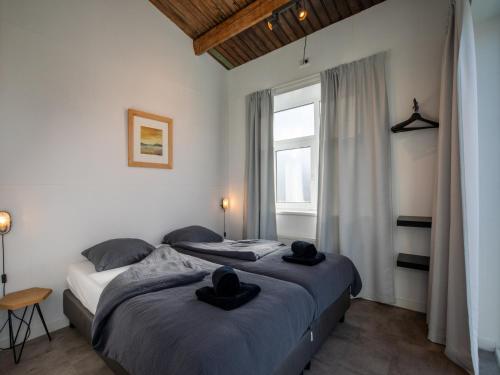 two beds in a bedroom with two hats on them at Lovely, modern, 4-person apartment in the heart of Koudekerke in Koudekerke