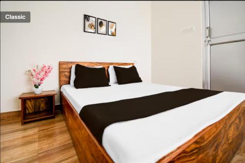 a bedroom with a large bed with white and black sheets at The Vasudha Estate in Lucknow