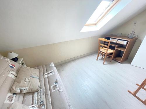 Cette chambre mansardée comprend un lit et un bureau. dans l'établissement Spacieux appartement pour 6 pers. avec balcon, Sarzeau - FR-1-639-147, à Sarzeau