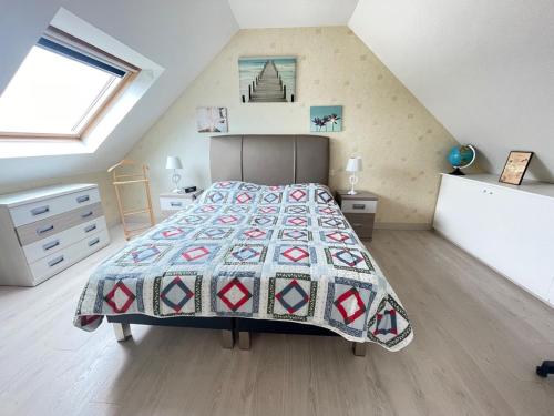 une chambre avec un lit avec une couette dessus dans l'établissement Spacieux appartement pour 6 pers. avec balcon, Sarzeau - FR-1-639-147, à Sarzeau