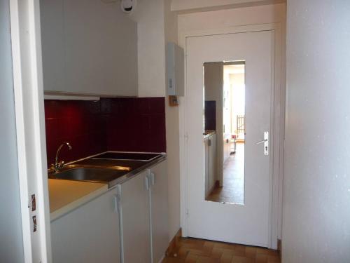 une cuisine avec un évier et une porte menant à un couloir dans l'établissement Studio Cabine RDC, 4 Pers, Accès Direct Plage - FR-1-782-78, au Barcarès