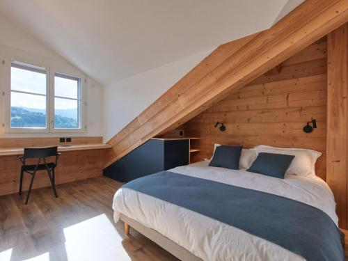 une chambre avec un grand lit avec un mur en bois dans l'établissement Duplex moderne 10 pers, Wi-Fi, parking, proche St-Gervais - FR-1-663-48, à Saint-Gervais-les-Bains