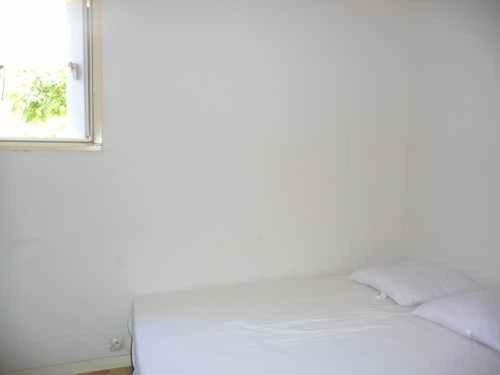 un lit dans une chambre avec une fenêtre dans l'établissement Appartement 2 pièces, accès plage, parking privé, Le Barcarès - FR-1-782-79, au Barcarès