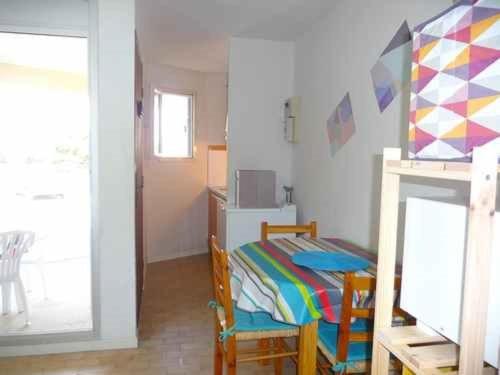 une chambre avec un lit, une table et des chaises dans l'établissement Appartement 2 pièces, accès plage, parking privé, Le Barcarès - FR-1-782-79, au Barcarès