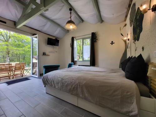 une chambre avec un grand lit et un patio dans l'établissement Retraite paisible en maisonnette au bord d'un lac - FR-1-839-3, à La Coquille
