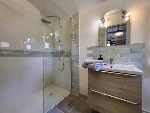 une salle de bain avec une douche en verre et un lavabo dans l'établissement Retraite paisible en maisonnette au bord d'un lac - FR-1-839-3, à La Coquille