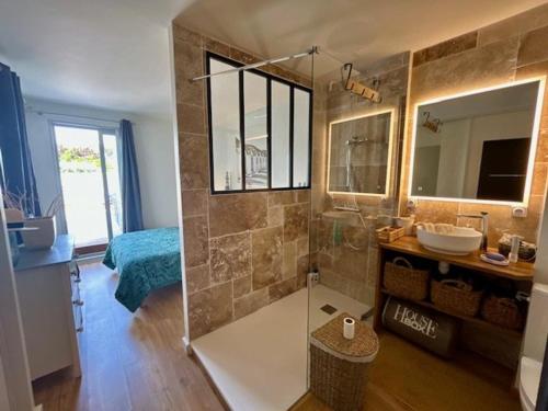 une salle de bain avec une douche avec un lavabo et un miroir dans l'établissement Bel appartement T3 rénové avec vue sur mer à Royan - FR-1-494-213, à Royan
