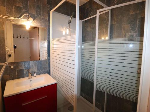une salle de bain avec un lavabo et une douche avec un miroir dans l'établissement 2 pièces avec loggia, piscine à 200m de la plage - FR-1-307-289, au Grau-du-Roi