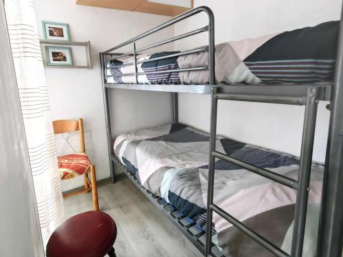Cette chambre comprend 2 lits superposés et une chaise. dans l'établissement Studio cabine 4 pers., proche plage, quartier Falaises - FR-1-607-225, au Cap d'Agde