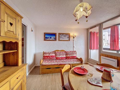 un salon avec une table et un canapé dans l'établissement Studio au pied des pistes avec balcon sud - FR-1-344-1229, aux Menuires
