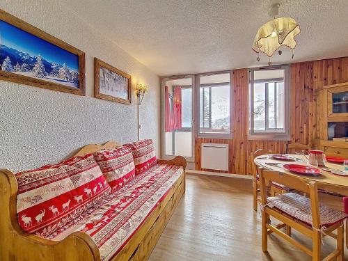 un salon avec un canapé et une table dans l'établissement Studio au pied des pistes avec balcon sud - FR-1-344-1229, aux Menuires