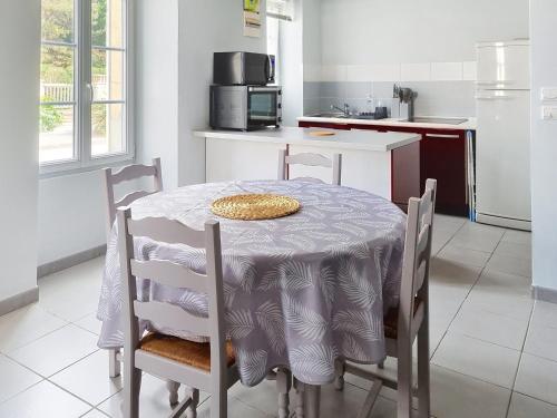 una cucina con tavolo, sedie e tovaglia di Studio proche mer à Saint-Aubin-sur-Mer - FR-1-746-32 a Saint-Aubin-sur-Mer