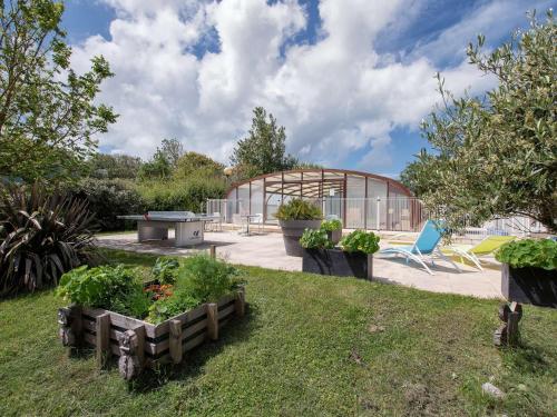 un jardin avec une serre et quelques plantes dans l'établissement Chalet 3 pièces Oléron 4 couchages SAINT DENIS DOLERON - FR-1-246A-360, à Saint-Denis-dʼOléron