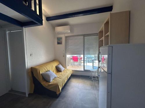 un salon avec un canapé et une fenêtre dans l'établissement Appt 2 pièces climatisé pour 4 pers, Le Grau-du-Roi - FR-1-250-314, au Grau-du-Roi