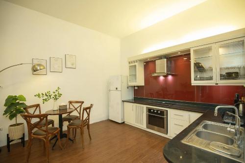 a kitchen with a table and chairs and a refrigerator at The Mira Villa West Lake by XÔI Residences in Hanoi