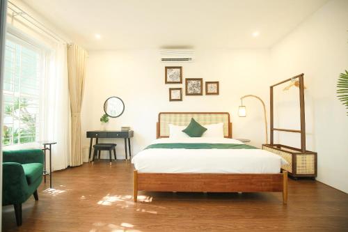 a bedroom with a bed and a desk in it at The Mira Villa West Lake by XÔI Residences in Hanoi