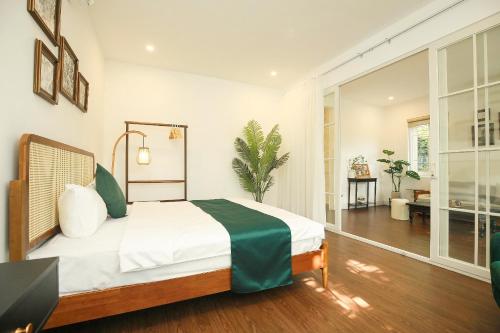 a bedroom with a bed and a living room at The Mira Villa West Lake by XÔI Residences in Hanoi