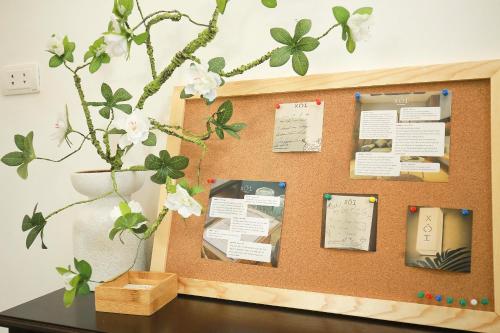 a cork bulletin board with flowers and papers on it at The Mira Villa West Lake by XÔI Residences in Hanoi