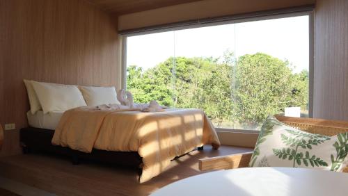 a bedroom with a bed and a large window at Port Kalaya in El Nido