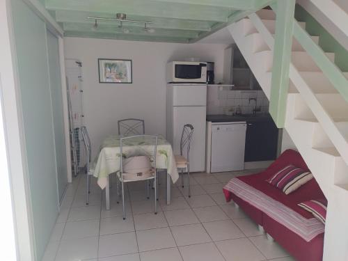 une chambre avec une table et une cuisine avec une cuisine dans l'établissement Noirmoutier : Maisonnette en résidence près de la plage, 5 pers, animaux admis - FR-1-823-81, à Barbâtre