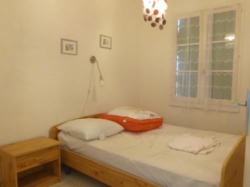 - une chambre avec un lit doté d'un oreiller orange dans l'établissement Noirmoutier : Maisonnette en résidence près de la plage, 5 pers, animaux admis - FR-1-823-81, à Barbâtre
