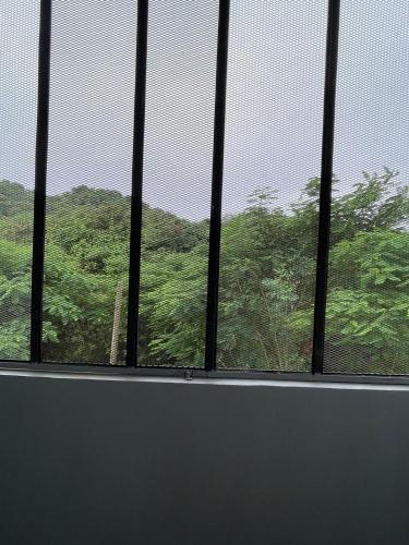 a window with a view of a mountain at ควีนเพลส สระบุรี Queenplace Saraburi in Sara Buri