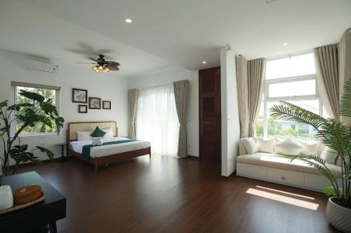 a living room with a bed and a couch at The Mira Villa West Lake by XÔI Residences in Hanoi