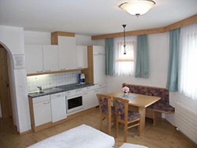 eine Küche mit einem Holztisch und einem Esszimmer in der Unterkunft Appartements Mattioli in Samnaun