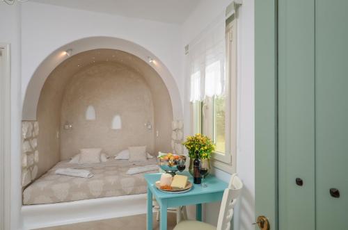 um quarto com uma cama e uma mesa azul em Naxos Euphoria Suites em Stelida