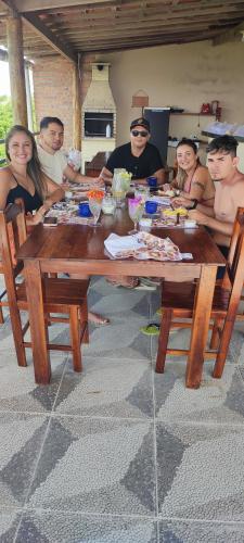 a group of people sitting around a wooden table at Pousada Zona do Kite Jeri in Jericoacoara