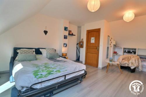 a bedroom with a large bed and a chair at La ranjardiere in Janzé