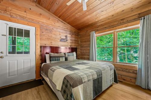 een slaapkamer met een bed in een houten hut bij Log Cabin, In-Room Jacuzzi, WiFi, Fireplace in Sevierville
