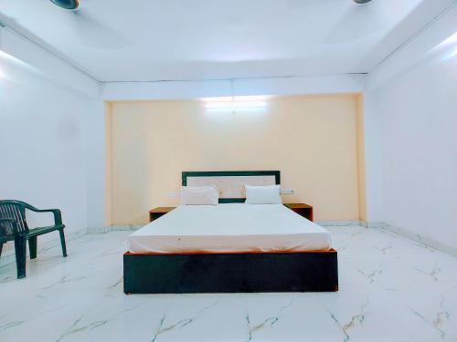a bedroom with a bed and a chair in it at Hotel Trilok a comfort Room in Lucknow