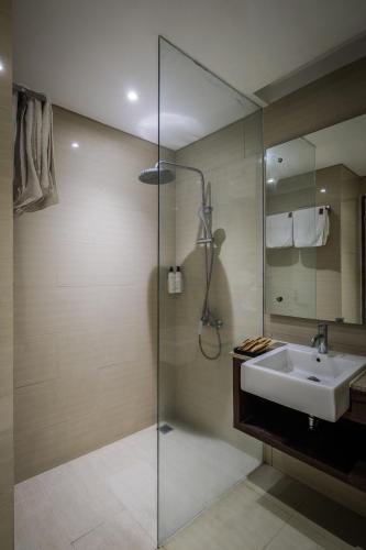 a bathroom with a sink and a glass shower at Clove Hotel Bandung in Bandung