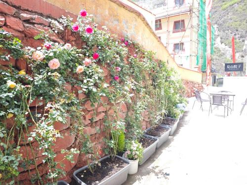a brick wall with flowers growing on it at Jiuzhaigou Mountain villa in Jiuzhaigou