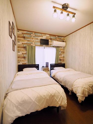 a room with two beds and a television in it at 202 Airport and Disneyland direct bus Near Koiwa st in Tokyo
