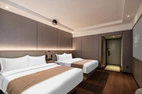 two beds in a hotel room with a tv at Jiuzhaigou Mountain villa in Jiuzhaigou