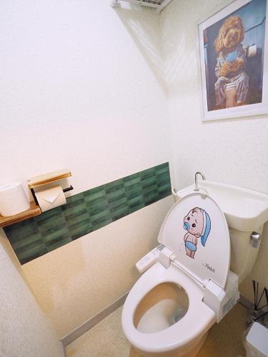 a bathroom with a toilet with a picture on the wall at 202 Airport and Disneyland direct bus Near Koiwa st in Tokyo