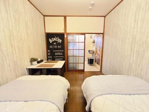 two beds in a room with a chalkboard on the wall at 202 Airport and Disneyland direct bus Near Koiwa st in Tokyo