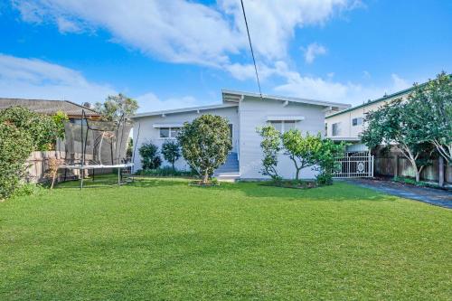 a white house with a yard at Yaringa -13 Seaview Street SWR in South West Rocks