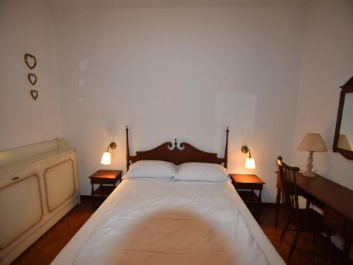 a bedroom with a large white bed with two lamps at Villa in Ghiffa with Lake Maggiore Views in Ghiffa