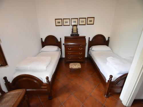 a room with two twin beds and a dresser at Villa in Ghiffa with Lake Maggiore Views in Ghiffa