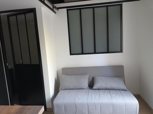 Cette chambre comprend un canapé, une fenêtre et un miroir. dans l'établissement Location estivale, à Aubagne