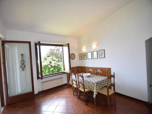 a dining room with a table and chairs and a window at Villa in Valdora with Lake Maggiore Views in Ghiffa