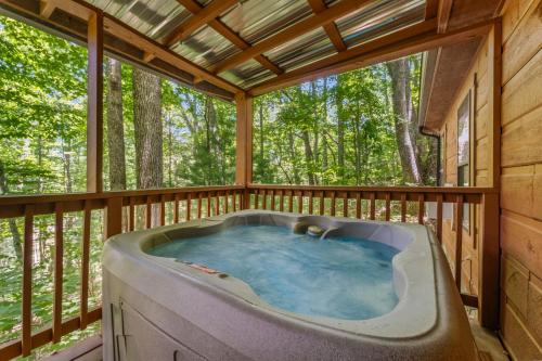 a jacuzzi tub on a deck with trees at MTN Views, Hot Tub, WiFi, Sleeps 3 in Sevierville