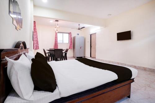 a bedroom with a bed and a dining room at Hotel O Moonlight Residency in Mumbai